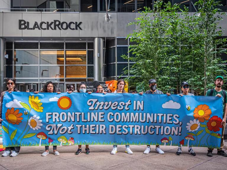 Young protesters stand with a banner that reads, "Invest in frontline communities, not their destruction!"