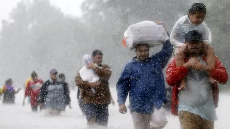 A blurry image of a line of people wading through floodwaters from Tropical Storm Harvey in Beaumont Place, Houston, Texas, 2017