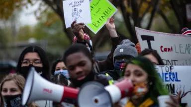 A crowd of people holding signs and megaphones