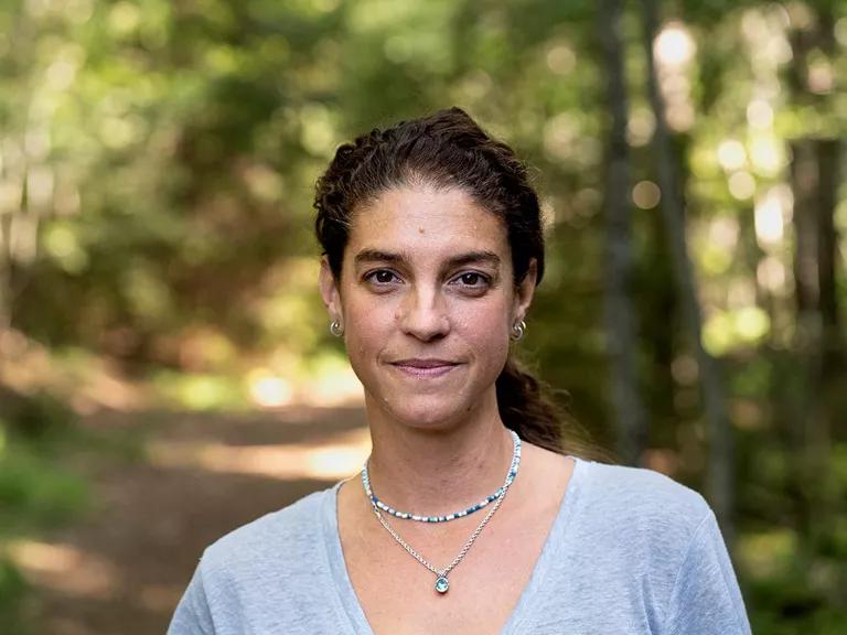 Portrait of a woman smiling directly at camera in the woods