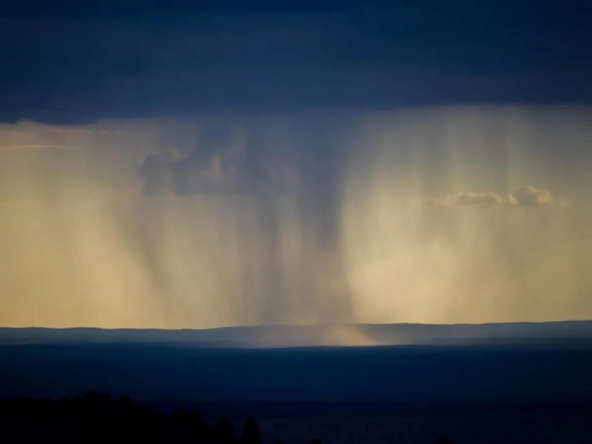 A storm cloud stretches from the ground to the sky