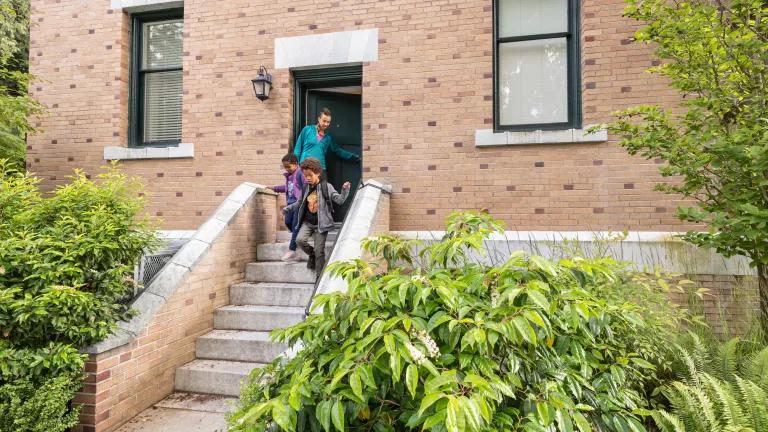 A family walking down the front steps of their home.