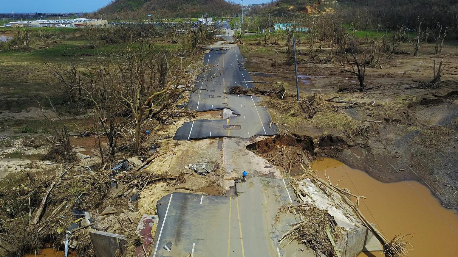 A cyclist riding on a flood damaged road following Hurricane Maria in Toa Alta, Puerto Rico