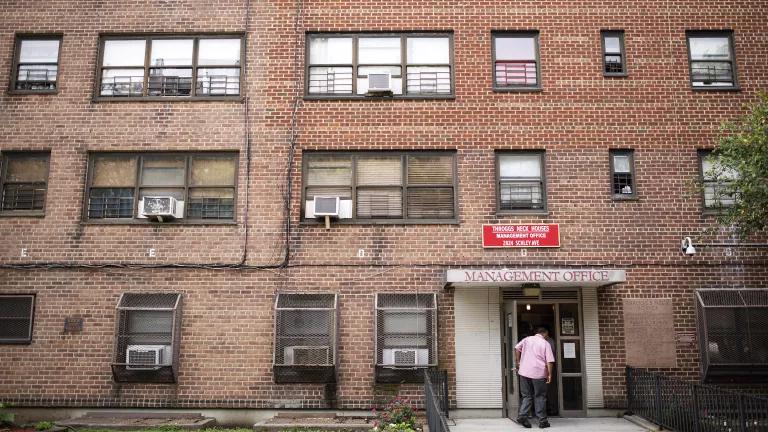 A person walks into a brick apartment building