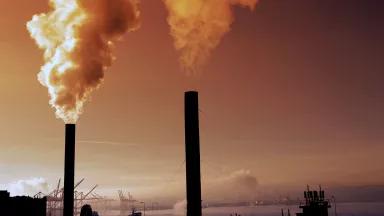 Smoke blows out of two tall industrial stacks 