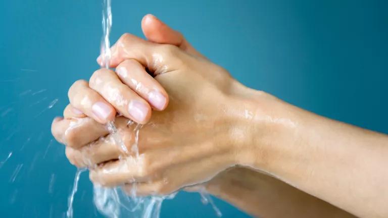 A pair of hands under a flow of running water