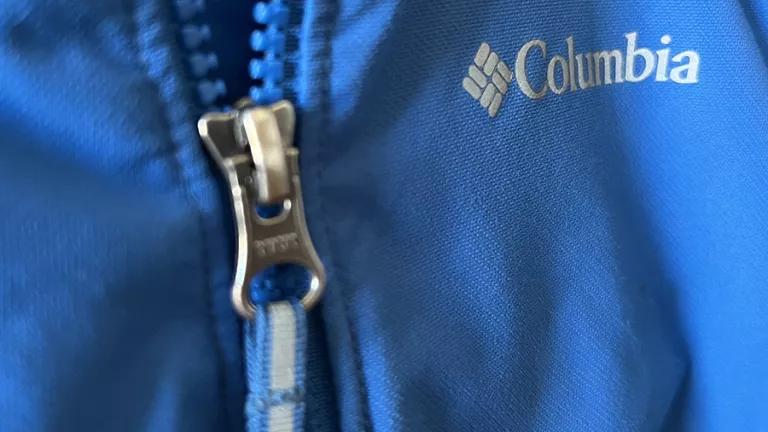 A closeup view of a jacket with a silver zipper and Columbia Sportswear logo