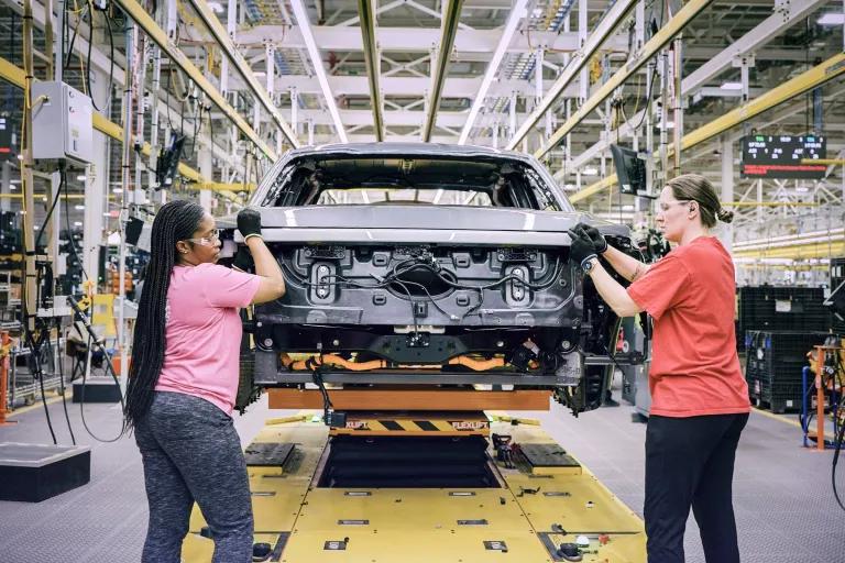 Two workers on an auto assembly line