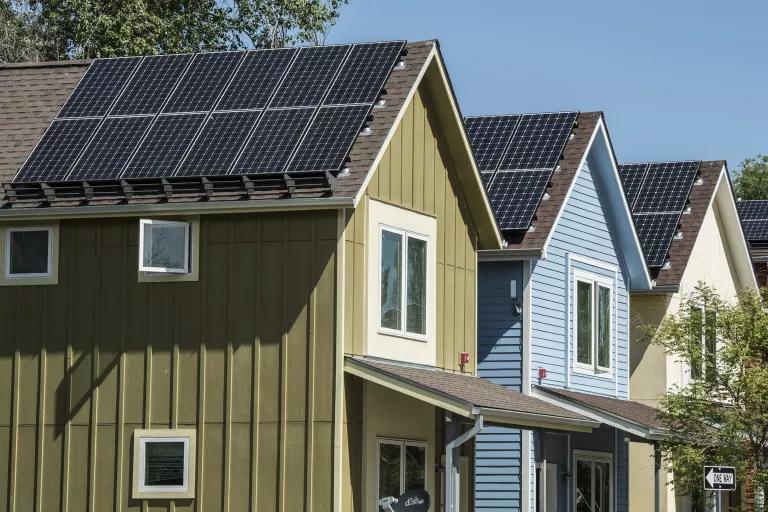 A row of houses each with solar panels on the roof