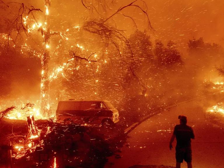 Bruce McDougal watches embers fly over his property as the Bond Fire burns through the Silverado community in Orange County, California, on December 3, 2020.