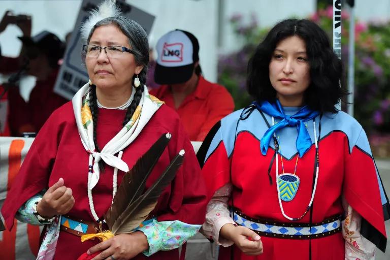 Two women stand together at a protest