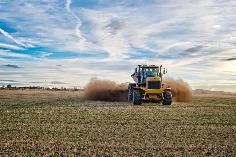 A large tractor moves through a field