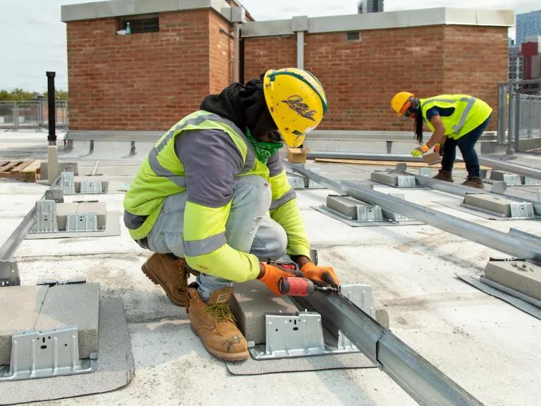 Workers installing rooftop solar panel arrays on one of the New York City Housing Authority's (NYCHA) buildings in Queens, New York City, April 22, 2021