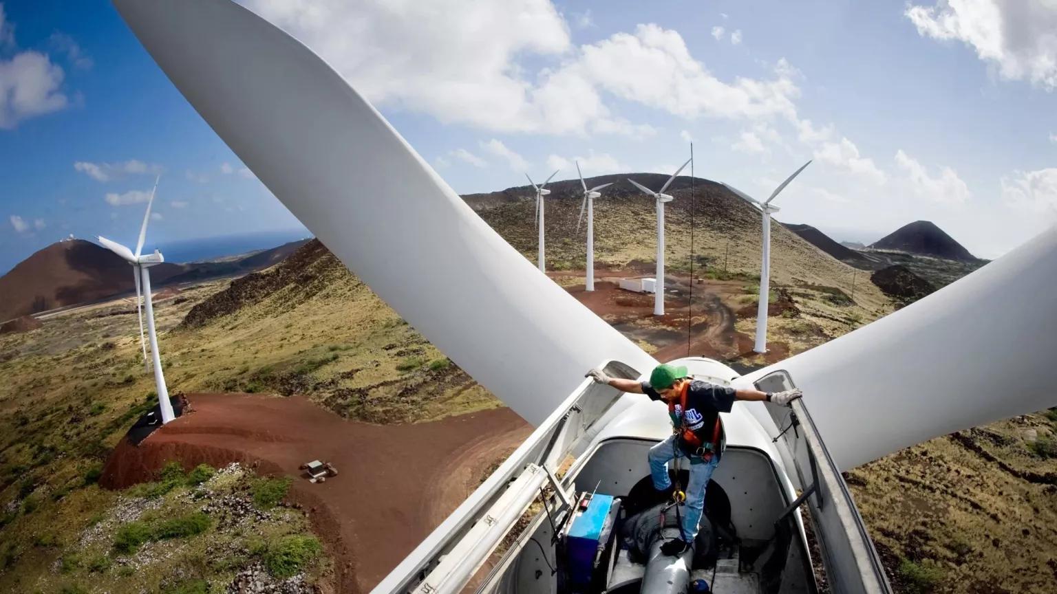 A technician working on top of a wind turbine