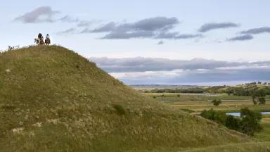 Indigenous horseback riders on a hill above the confluence of the Cannonball and Missouri Rivers in North Dakota